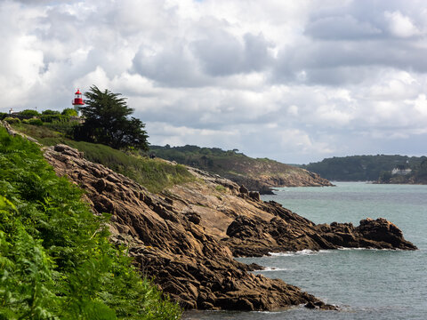 The indented rocky coastline in Port Manech with its lighthouse