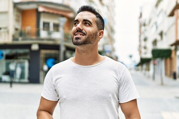Fototapeta premium Young hispanic man smiling confident walking at street