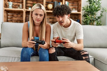 Young couple frustrared playing video game at home.