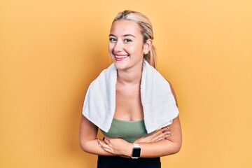 Young blonde girl wearing sportswear and towel smiling and laughing hard out loud because funny...