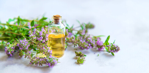 Obraz na płótnie Canvas Thyme essential oil in a small bottle. Selective focus.