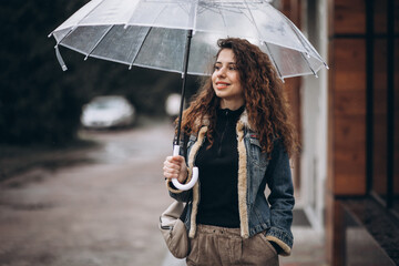 Woman walking under the umbrella in a rainy weather