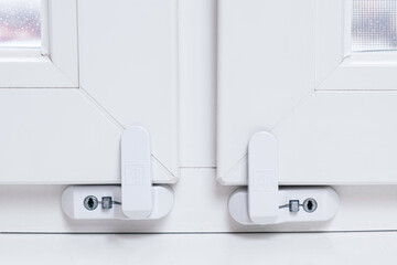 Close-up of child safety lock on a window frame an apartment on a high floor. Security lock for...