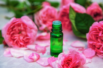 Obraz na płótnie Canvas Rose essential oil in a small bottle. Selective focus.