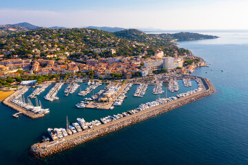 Aerial panoramic view of French commune of Sainte-Maxime on shore of Gulf of Saint-Tropez overlooking large marina on sunny summer day, Var department