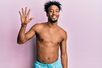 Fototapeta premium Young african american man with beard wearing swimsuit showing and pointing up with fingers number five while smiling confident and happy.