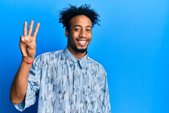 Young african american man with beard wearing casual clothes showing and pointing up with fingers number three while smiling confident and happy.