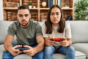 Young latin couple frustrated playing video game at home. © Krakenimages.com