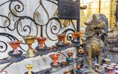Candles and lion statue at the Swayambhunath temple in Kathmandu, Nepal