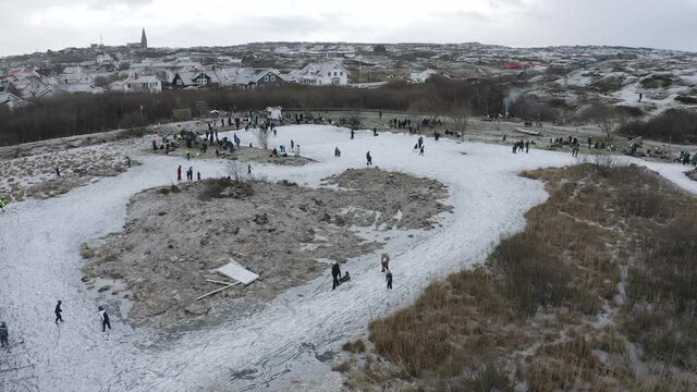 Drone shot of people and families ice skating with his ice skates at Öckerö Island Municipality in Gothenburg archipelago, Sweden.