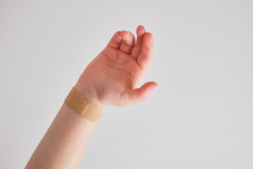 plaster on a child's hand on gray background, selective focus, copy place, medical plaster on a vein