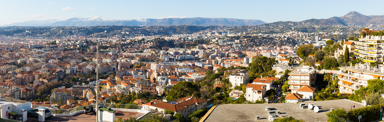 Fototapeta na wymiar Panoramic view of Nice residential districts against backdrop of Alps in sunny day, France