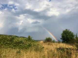 Rainbow in countryside at summer day