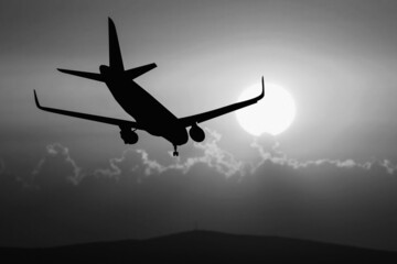Silhouette of a passenger flight story with tourists landing at the airport. Airplane landing at...