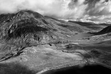 Fototapeta na wymiar Black and white Aerial view of flying drone Epic Autumn Fall landscape image of view along Ogwen vslley in Snowdonia National Park with moody sky and mountains