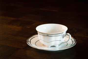 Porcelain empty cup for tea or coffee on wooden dark table