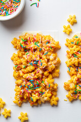 Children corn stars cereal bars with colored sprinkles and white chocolate on a white background.