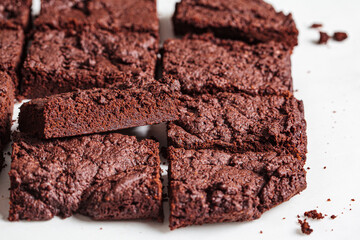 Vegan brownie squares on a white table.