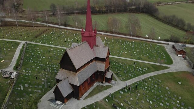 Historical Wooden Church With A Red Spire, Stave Church of Ringebu, Gudbrandsdal, Oppland, Norway - aerial drone shot