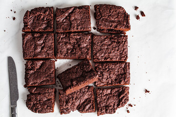 Vegan brownie squares on a white table.