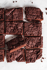 Vegan brownie squares on a white table.