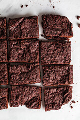 Vegan brownie squares on a white table.
