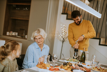 Young man opening bottle of red wine during at home