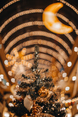 Christmas tree decorated with Christmas balls. Magic cozy details, golden bokeh lights and moon,...