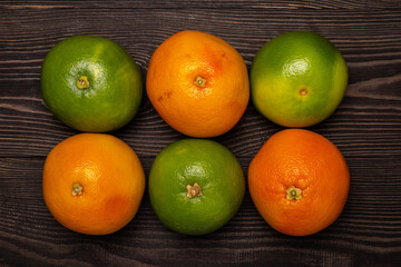 green and orange grapefruits a dark background top view