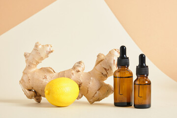 lemon, amber glass dropper bottles and ginger root on beige background copy space natural cosmetic...