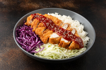 Crispy Katsu chicken with sauce, rice and cabbage. © grinchh