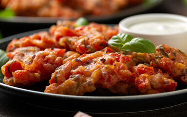 Greek tomato fritters, tomatokeftedes served with yogurt on plate.