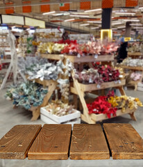 Wooden board on the background of the interior of the supermarket.  Sharpness on the board. Place for product advertising. Free space for design and goods. Layout for products.