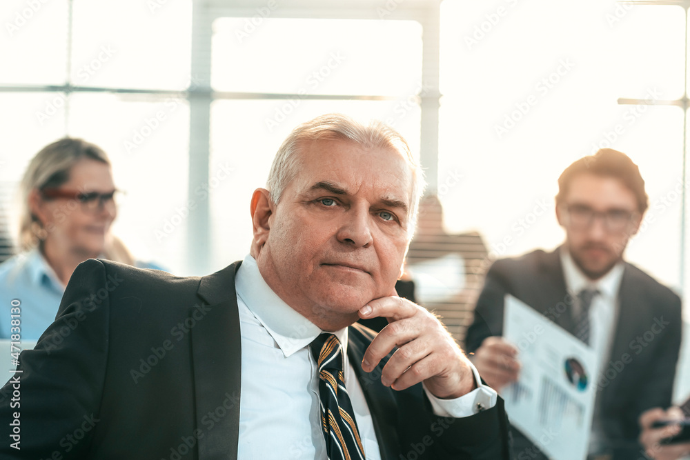 Poster close up. boss sitting in front of his Desk