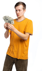 a guy in old clothes, a man in an orange T-shirt, a man holding a fan of money, looking at dollars in surprise, his lips stretched out, his eyes bulging. the crisis. isolated white background