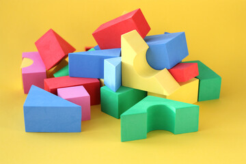 Bright cubes are scattered randomly on a yellow surface. Children's educational game for young children.