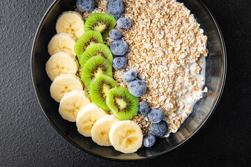 oatmeal fruit breakfast milk, banana, kiwi, berrie, blueberrie meal snack on the table copy space food background