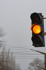 A traffic light showing a yellow light and requiring attention. Regulation of street traffic, using...
