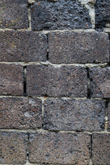 An old stone wall made of rectangular blocks. Textured background of a stone wall, with an unusual texture.