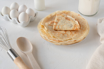 Thin pancakes with sour cream. White background. Nice breakfast. Pancake ingredients.