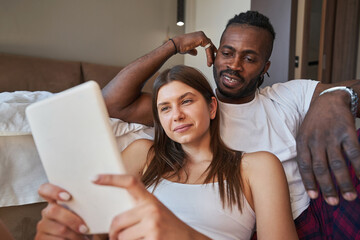 Concentrated female and man watching something on gadget