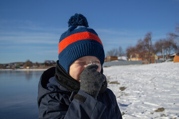 Fototapeta na wymiar a boy in winter on the lake shore