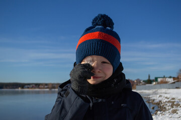 Fototapeta na wymiar a boy in winter on the lake shore