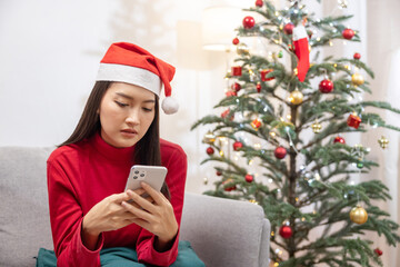 Depressed Asian Woman Spend Her Christmas Time Alone at Home Watching on Her Mobilephone Screen