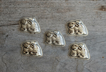 Vintage metal rabbit shape baking molds for cupcakes on a wooden board