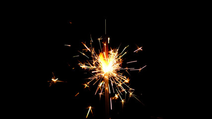 Fototapeta premium Burning sparkler isolated on black background. Festive Sparkler. Celebration, Success, New Years Concept