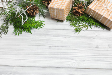 Christmas branches, gift boxes and pine cones on white wooden table. Christmas background. Flat lay. top view with copy space - Image