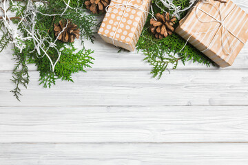 Christmas branches, gift boxes and pine cones on white wooden table. Christmas background. Flat lay. top view with copy space - Image