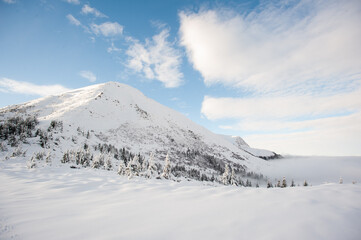 Fototapeta na wymiar Panorama of snow-capped mountains, snow and clouds on the horizon