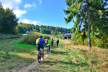 Outdoor sport activity.Tourists hiking  and riding on bikes in nature, Beskid Sadecki, Hala Labowska, Poland